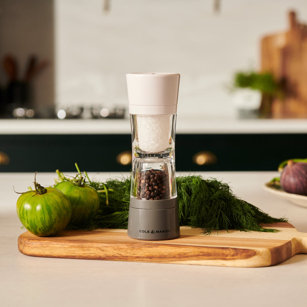 The Cole & Mason Lincoln 2-in-1 Duo Mill grinder has adjustable settings, a white top for salt, and a black base for peppercorns, shown against a light background.