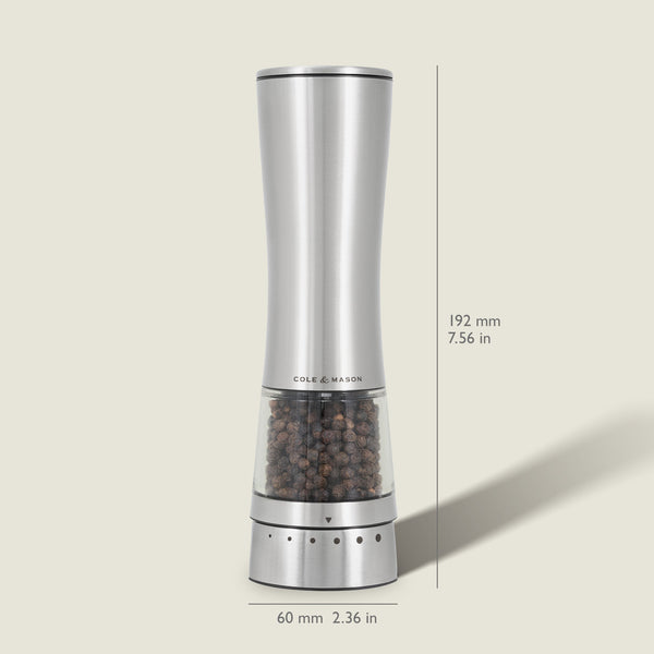 The Cole & Mason Electric Derwent Pepper Mill features a tall, silver design with a transparent lower section filled with peppercorns, measuring 7.56 in (192 mm) high and 2.36 in (60 mm) wide.