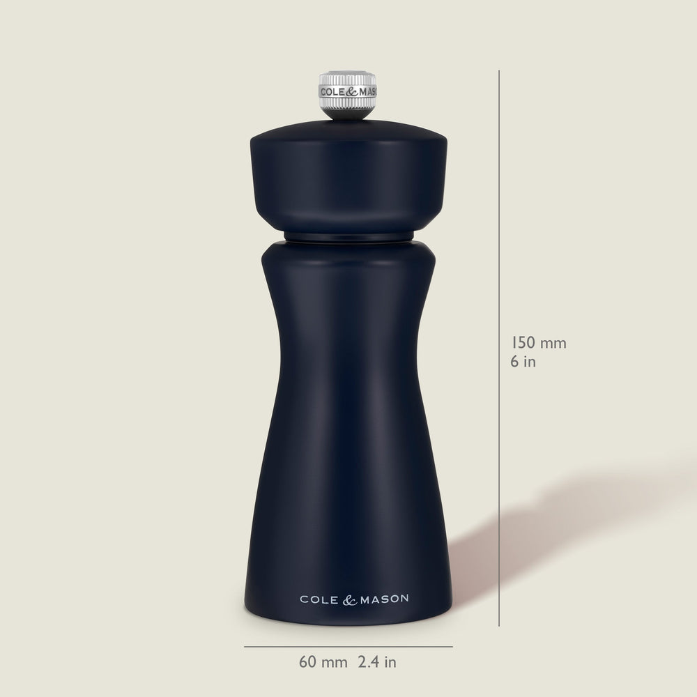 A Persian Blue Cole & Mason Kenton Salt & Pepper Mill, featuring a high-quality ceramic grinder and a sleek design, stands upright on a light beige background, casting a soft shadow to the right.