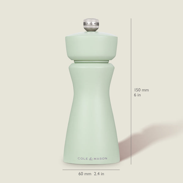 The Cole & Mason Kenton Sage Salt & Pepper Mill stands upright, displaying a pale green hue and durable ceramic mechanism. Size: 150 mm (6 in) tall, 60 mm (2.4 in) wide at the base. Background is off-white.