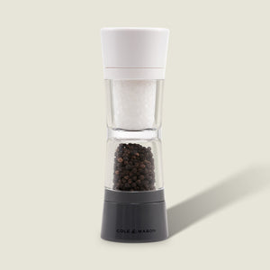 The Cole & Mason Lincoln 2-in-1 Duo Mill grinder has adjustable settings, a white top for salt, and a black base for peppercorns, shown against a light background.