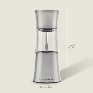 The Cole & Mason Stadhampton Chilli & Spice Mill, made of stainless steel and clear acrylic, stands upright with an ergonomic design, measuring 165 mm high and 66 mm wide. It is shown against a light background.